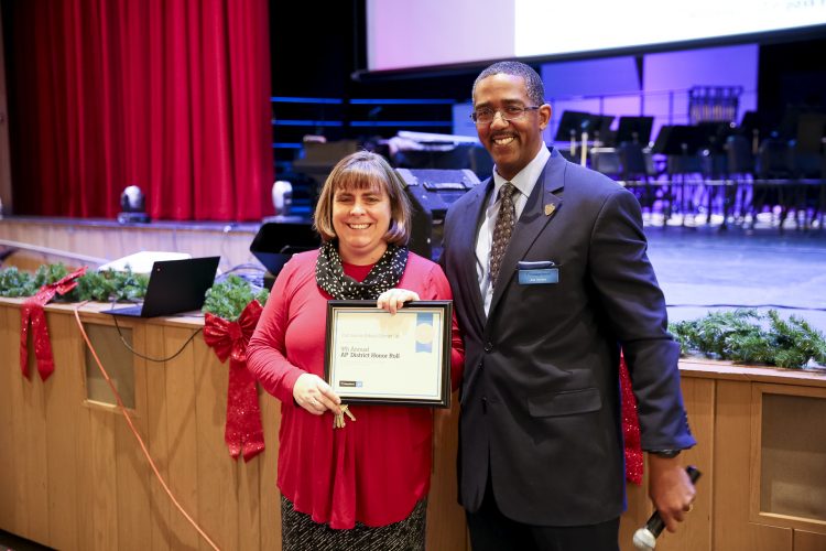 Principal Marina Kosak accepts East High's certificate from Asa Gordon from the College Board