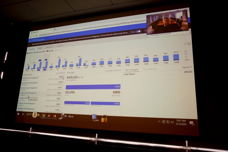 In the conference room, the students viewed a large projection screen displaying the sale taking place live on a website