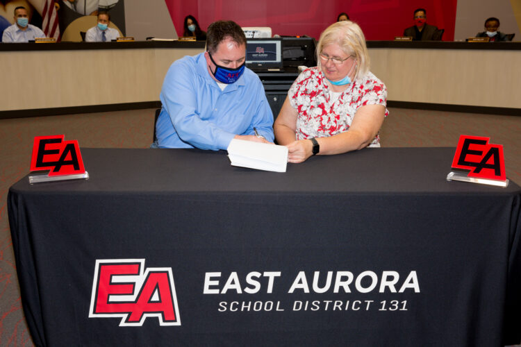 Jeff Mleczko, President, East Aurora Council IFT/AFT Local 604 and Annette Johnson, President, EASD 131 Board of Education, sign a new five-year contractual agreement at the Board of Education meeting on September 20, 2021.