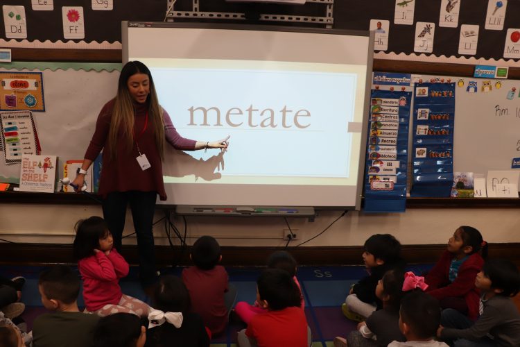 Miss Sosa teaches students to read words in Spanish. 