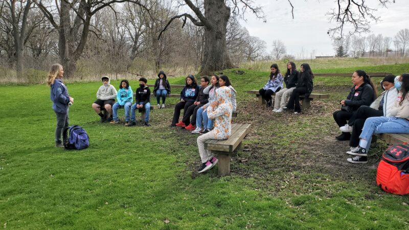 Students listen to a Kane County Forest Preserve Ranger give directions for a hike.
