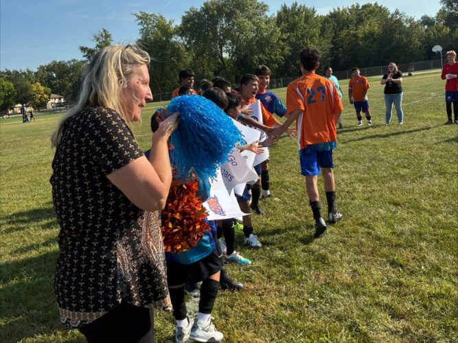 Dr. O'Brien helping the 6th and 7th grade boys cheer on their teammates